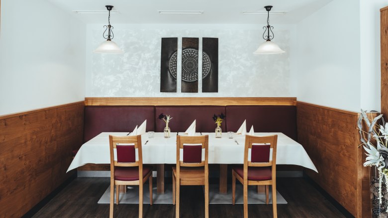 Innovation trifft Tradition in Groß Gerungs, © Niederösterreich Werbung/David Schreiber Ein stilvoll gedeckter Tisch in einem Restaurant mit Holzverkleidung und moderner Kunst an der Wand.