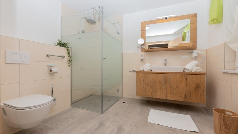 Badezimmer, © Schönfelderhof Modernes Badezimmer mit Dusche, Waschbecken und Toilette.