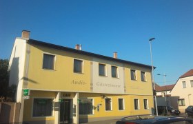 Haus, © zahnt Gelbes Gebäude mit der Aufschrift 'Andis Gästezimmer' und 'Cafe'.