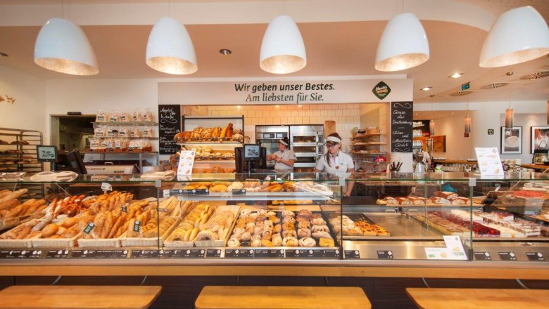 Café Haubiversum, © Haubis GmbH Innenansicht einer Bäckerei mit Theke voller Backwaren und zwei Angestellten.