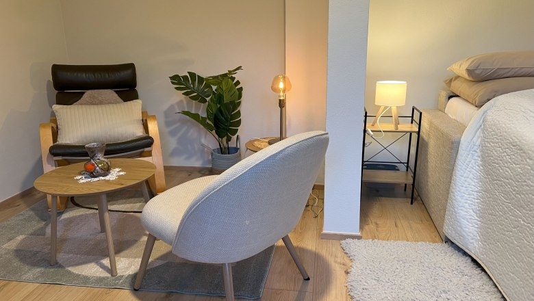 Schlafzimmer, © Waltraud Forstner Gemütliches Schlafzimmer mit Sessel, Tisch, Pflanze und Bett.