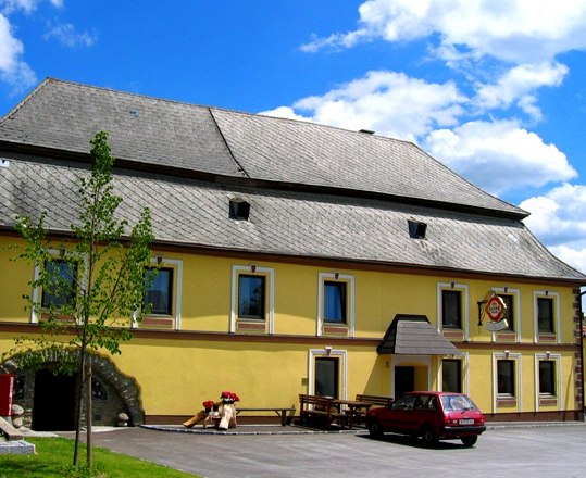Gasthaus Fichtinger, © Marktgemeinde Bad Traunstein Gelbes Gasthaus mit grauem Dach und rotem Auto davor.