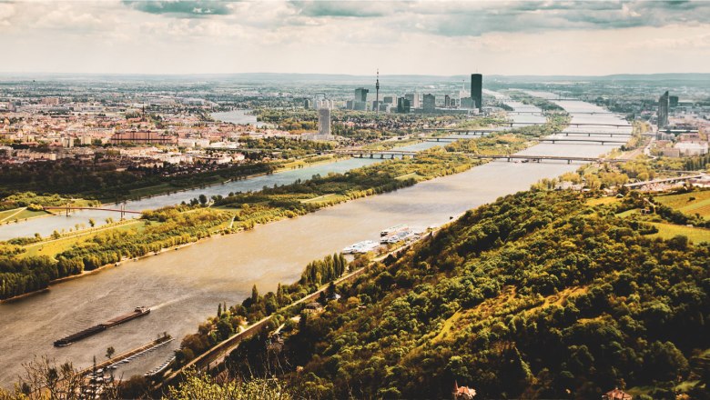 Bootanlegestelle Wien-Nussdorf, © Donaustationen Luftaufnahme von Wien mit der Donau und grünen Hügeln im Vordergrund.