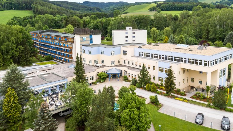 Luftaufnahme, © Gesundheitsresort Königsberg Luftaufnahme eines großen Gebäudekomplexes in einer grünen Landschaft.