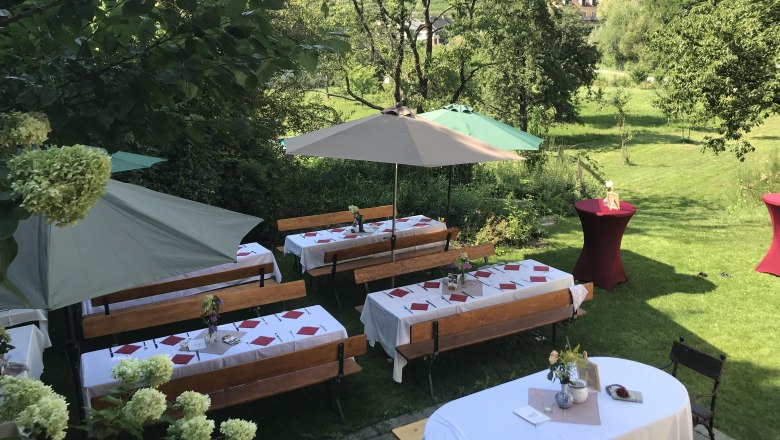 Festlich gedeckte Tische, © Monika Pölzer Festlich gedeckte Tische im Freien mit Sonnenschirmen und Blumenarrangements.