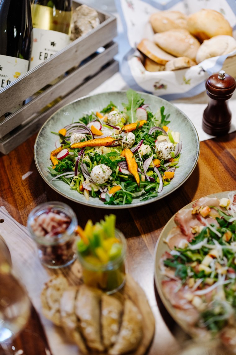 Ziegenkäse-Wintersalat & Wölblinger Carpaccio, © Niederösterreich Werbung/Mara Hohla Tischaufnahme einer Heurigenjause mit Wein und Brot