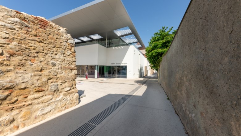 Museum St. Peter an der Sperr aus der Petersgasse, © Wiener Alpen/Christoph Schubert Eingang des Museums St. Peter an der Sperr mit moderner Architektur und alten Mauern.