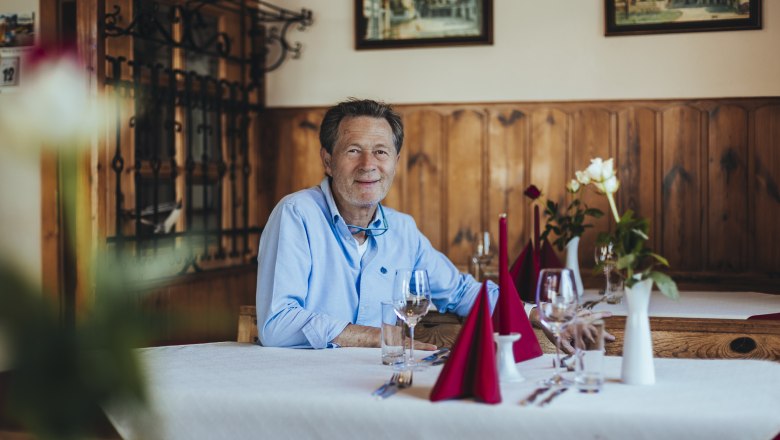 Karlheinz Ringl, © Niederösterreich Werbung/David Schreiber Karlheinz Ringl sitzt an einem gedeckten Tisch in seinem Gasthaus.