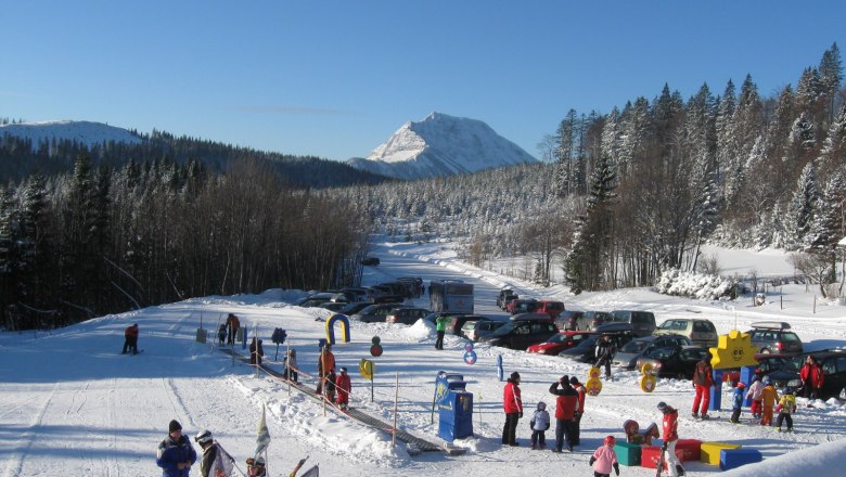 Lifte in Puchenstuben, © Schilifte Puchenstuben GesmbH & Co KG Winterlandschaft mit Skilift und spielenden Kindern in Puchenstuben.