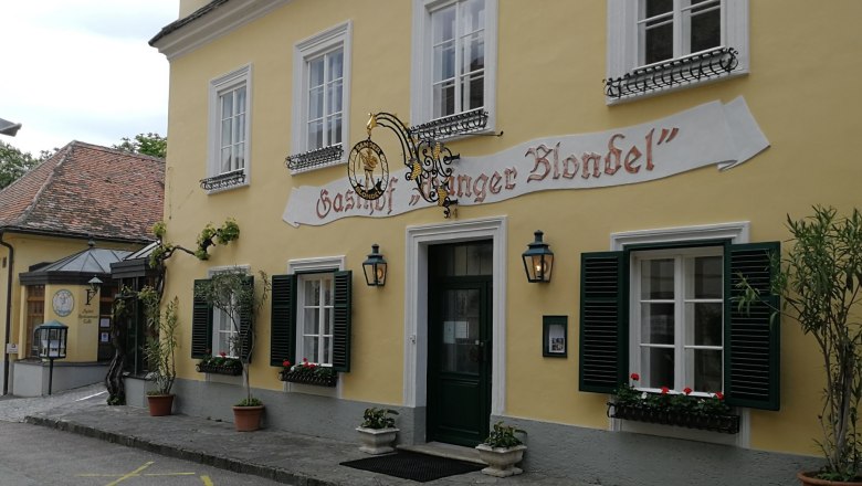 Restaurant Sänger Blondel, © Roman Zöchlinger Gelbes Gebäude mit der Aufschrift 'Gasthof Sänger Blondel', Fenster mit grünen Fensterläden und Blumenkästen.