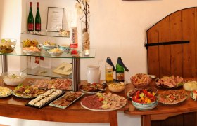Weingut ZOTTL, © Weingut Zottl Ein Buffet mit verschiedenen Speisen und Getränken auf einem Holztisch.