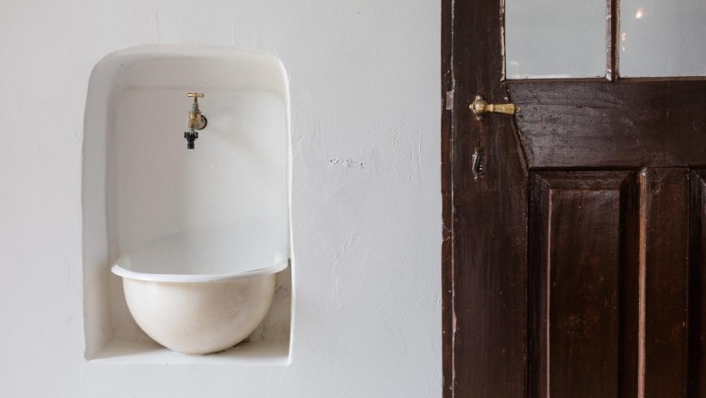 Klinger's Gästehaus, © Astrid Bartl Ein alter Wasserhahn über einem eingelassenen Becken neben einer Holztür.