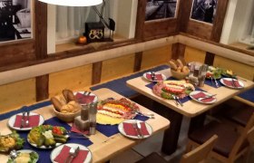 Bahnhofsbrauerei, © Bahnhofsbräu Styx Ein gedeckter Tisch in einem rustikalen Restaurant mit Brot, Aufschnitt und Salaten.