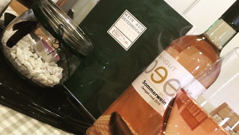 Rosé, © Weingut Peer Eine Flasche Roséwein und ein gefülltes Weinglas auf einem Tisch mit Dekoration.