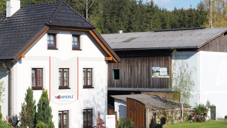 Mohnmühle Weinmann, © MG Sallingberg Gebäude der Mohnmühle Weinmann mit angrenzendem Holzschuppen, umgeben von Bäumen.