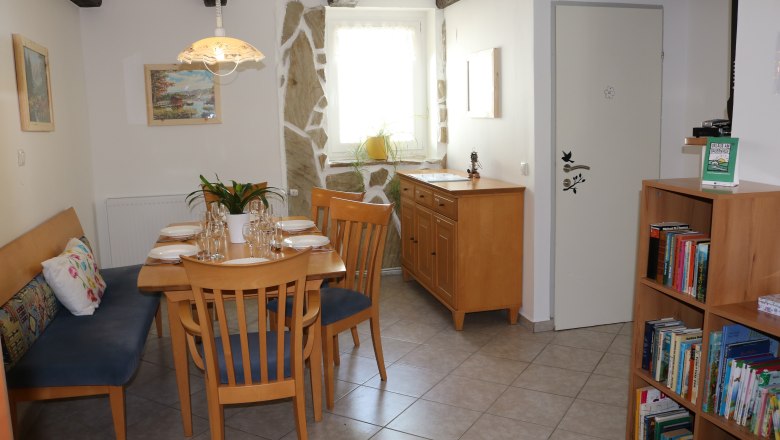 Essbereich Gaeste 6, © Gruber Claudia Essbereich mit Holztisch, Stühlen und Bücherregal.