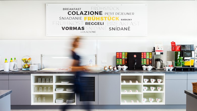 Frühstück, © Hotel Tullnerfeld Eine lange graue Theke mit Tassen und Geschirr. Auf der Theke befindet sich Alles für Kaffee und Tee.