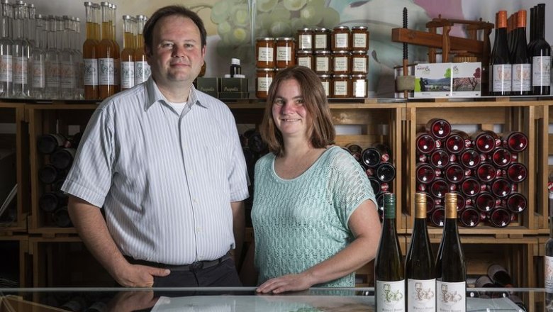 Weingut Böhmer, © Monika Loeff Zwei Personen stehen in einem Weingut vor Weinflaschen und Regalen mit Produkten.