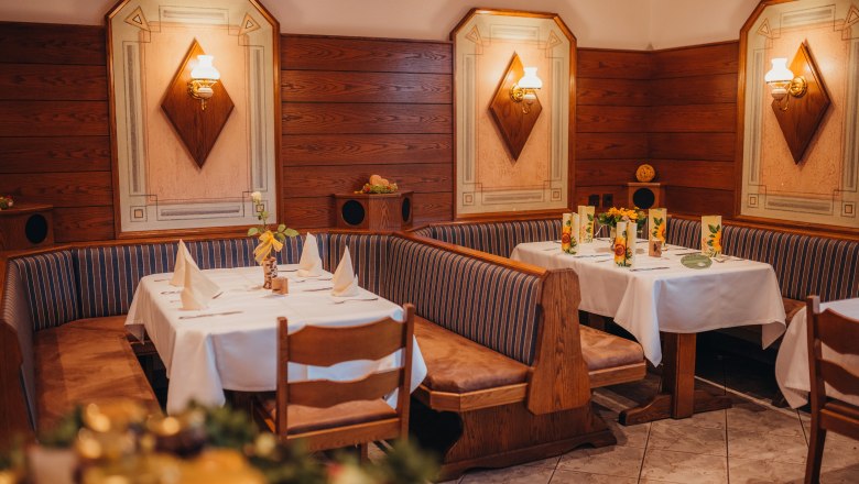 Ausgangspunkt für Wanderungen auf der Dirndl-Meile, © Niederösterreich Werbung/Daniela Führer Gemütliches Restaurant mit Holzwänden und dekorierten Tischen.