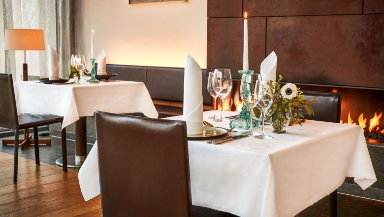 Restaurant Cuve Club, © Steigenberger Hotel and Spa, Gregor Titze Elegantes Restaurant mit gedecktem Tisch, Kerzen und Kamin.