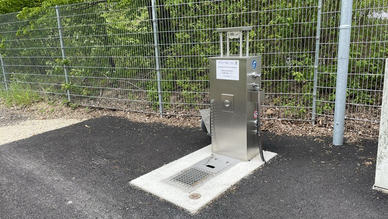 Wasserversorgung, © Stadtgemeinde Maissau Metallene Wasserversorgungsstation neben einem Zaun auf Asphalt.