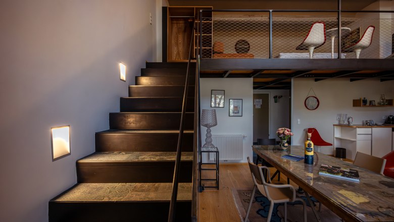 At the Park Hotel, © Niederösterreich Werbung / Maximilian Pawlikowsky Innenansicht eines modernen Hotelzimmers mit Treppe, Tisch und Stühlen.