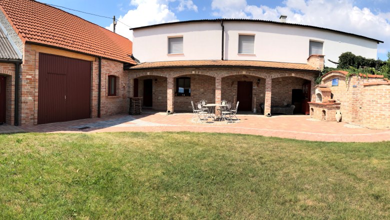 Garten, © Reinhard Gurschka Backsteinbau mit Garten und Terrasse bei sonnigem Wetter.