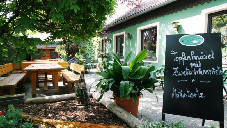 Bonka - Das Wirtshaus im Wienerwald, © Bonka Gemütlicher Gastgarten mit Holzbänken und Tafel im Wirtshaus Bonka, Wienerwald.