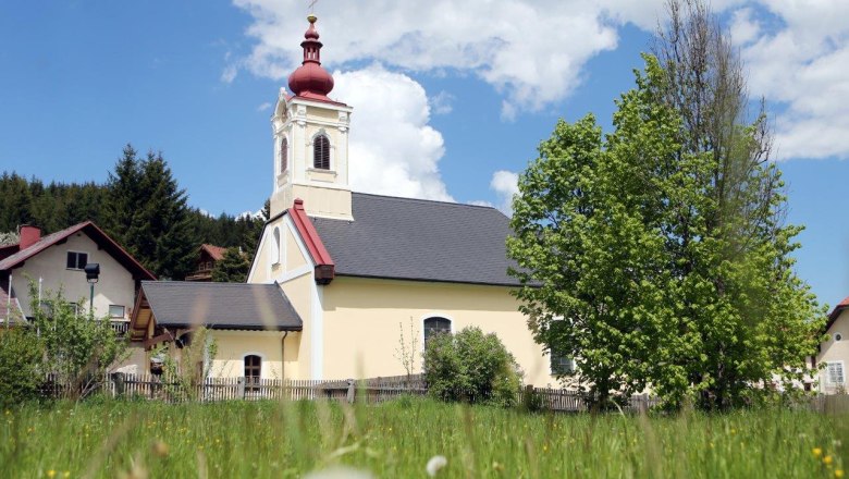 Kirche in Mitterbach, © weinfranz.at Kirche in Mitterbach mit rotem Turm und grünem Baum im Vordergrund.