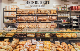 Heindl Brot, © Heindlbrot Bäckerei mit verschiedenen Broten und Gebäck in Regalen und Vitrinen.