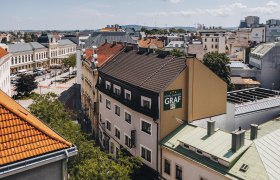 Hotel-Gasthof im Zentrum von St. Pölten, © Niederösterreich-Werbung/David Schreiber Luftaufnahme eines Hotel-Gasthofs in St. Pölten mit umliegenden Gebäuden und Straßen.
