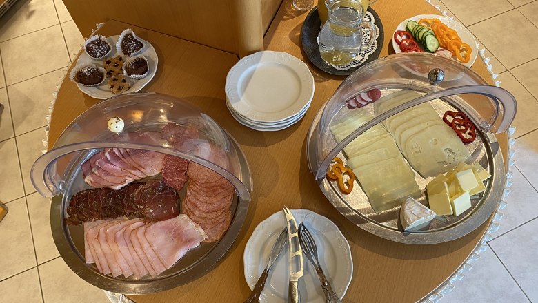 Frühstücksbüffet, © Privatzimmer Leeb Ein Frühstücksbüffet mit Aufschnitt, Käse, Gemüse, Gebäck und Getränken auf einem Tisch.
