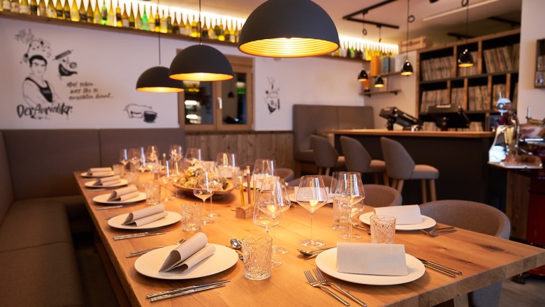 Genuss MEISTEREI Heiligeneich, © Philipp Monihart – www.charakter.photos Eleganter, gedeckter Tisch in einem stilvollen Restaurant mit warmem Licht und moderner Dekoration.