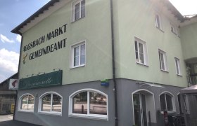 Donauwelle in Aggsbach Außenansicht, © Donau NÖ Tourismus Grünes Gebäude mit Aufschrift 'Aggsbach Markt Gemeindeamt' und Café Donauwelle.