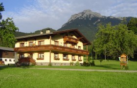 Biobauernhof Moar, © zVg Ein traditionelles Bauernhaus vor einem Berg in einer grünen Landschaft.