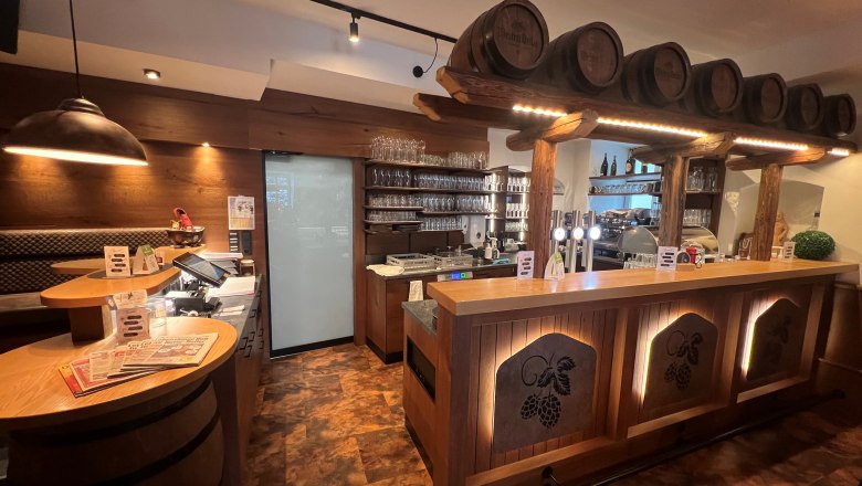 Rustikales Wirtshausflair, © Matthias Bachofner Rustikale Bar mit Holzverkleidung und Bierfässern als Dekoration.