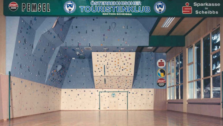 Kletterhalle, © ÖTK Scheibbs Innenansicht einer Kletterhalle mit blauer Kletterwand und bunten Griffen.