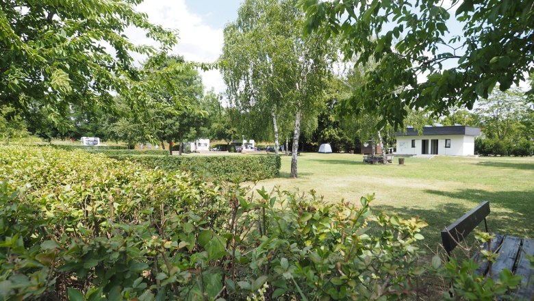Stellplatz auf einer frisch gem&auml;hten Wiese. Abgegrenzt durch eine Hecke.