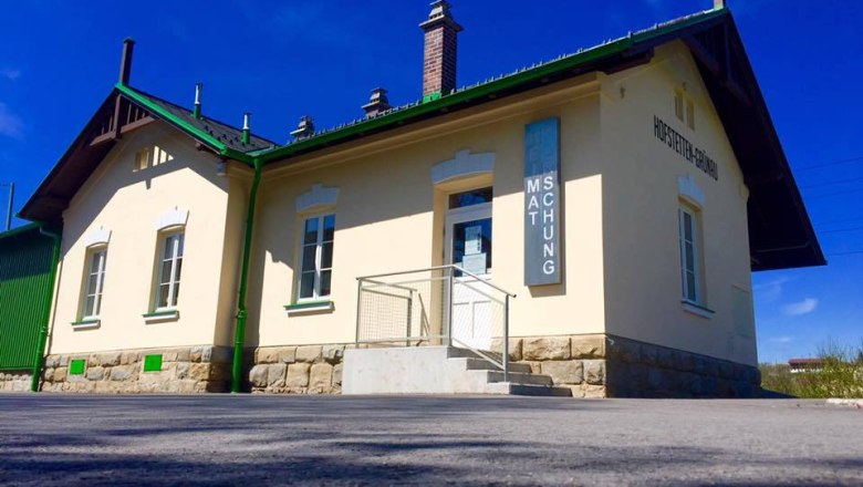 Außenansicht eines kleinen Museumsgebäudes mit gelber Fassade und grünen Akzenten.