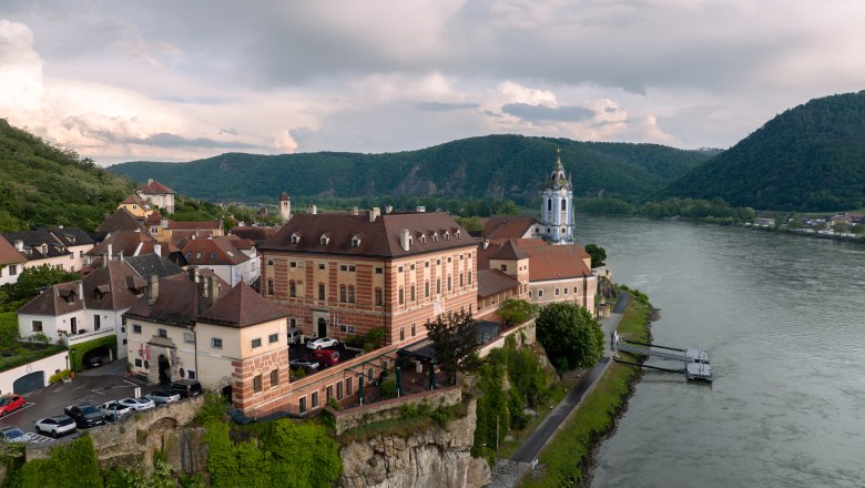 Hotel Schloss Dürnstein, © Niederösterreich Werbung / Maximilian Pawlikowsky Luftaufnahme von Schloss Dürnstein an der Donau mit umliegender Landschaft.