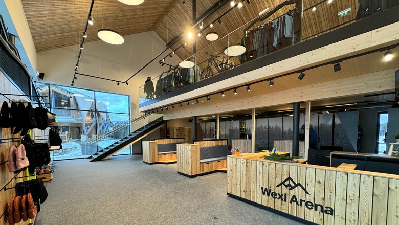 Innenansicht des Wexl Base Servicezentrums mit Holzm&ouml;beln und einer Treppe.