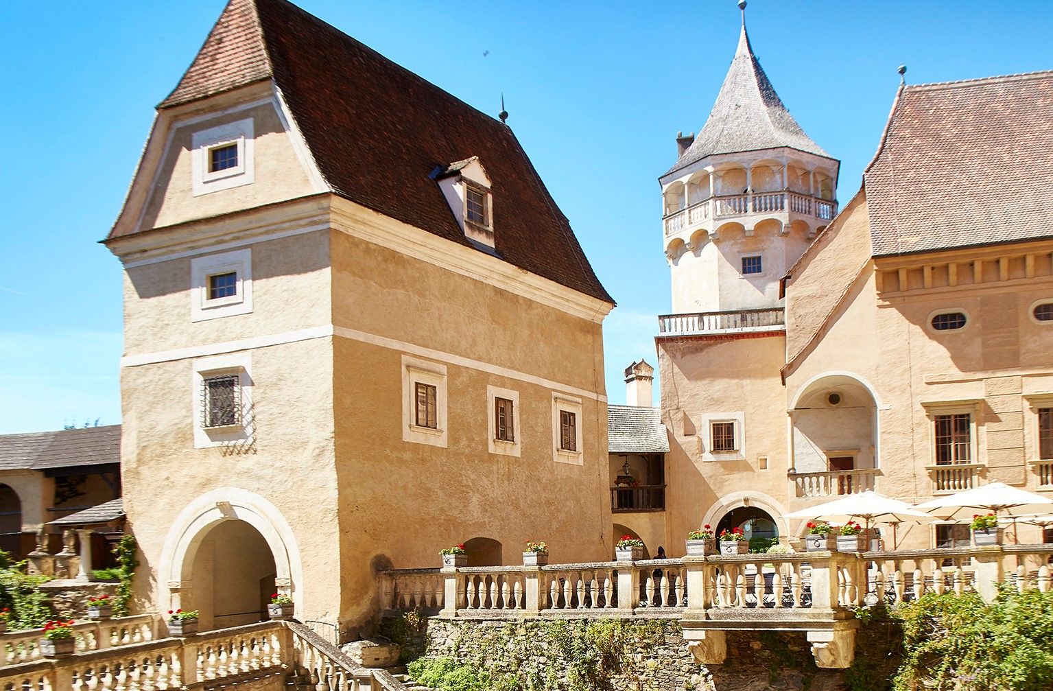 Historische Burg mit Türmen und Zinnen unter blauem Himmel.
