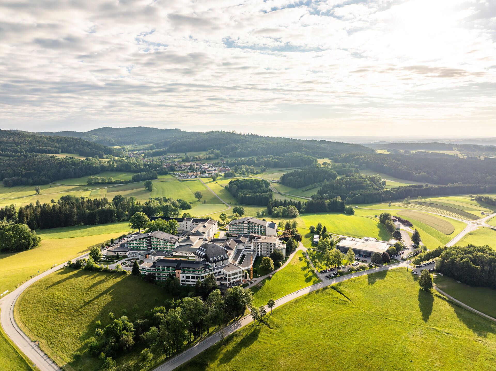 Luftaufnahme des Moorheilbads Harbach im Waldviertel, umgeben von grünen Wiesen, Feldern und bewaldeten Hügeln.