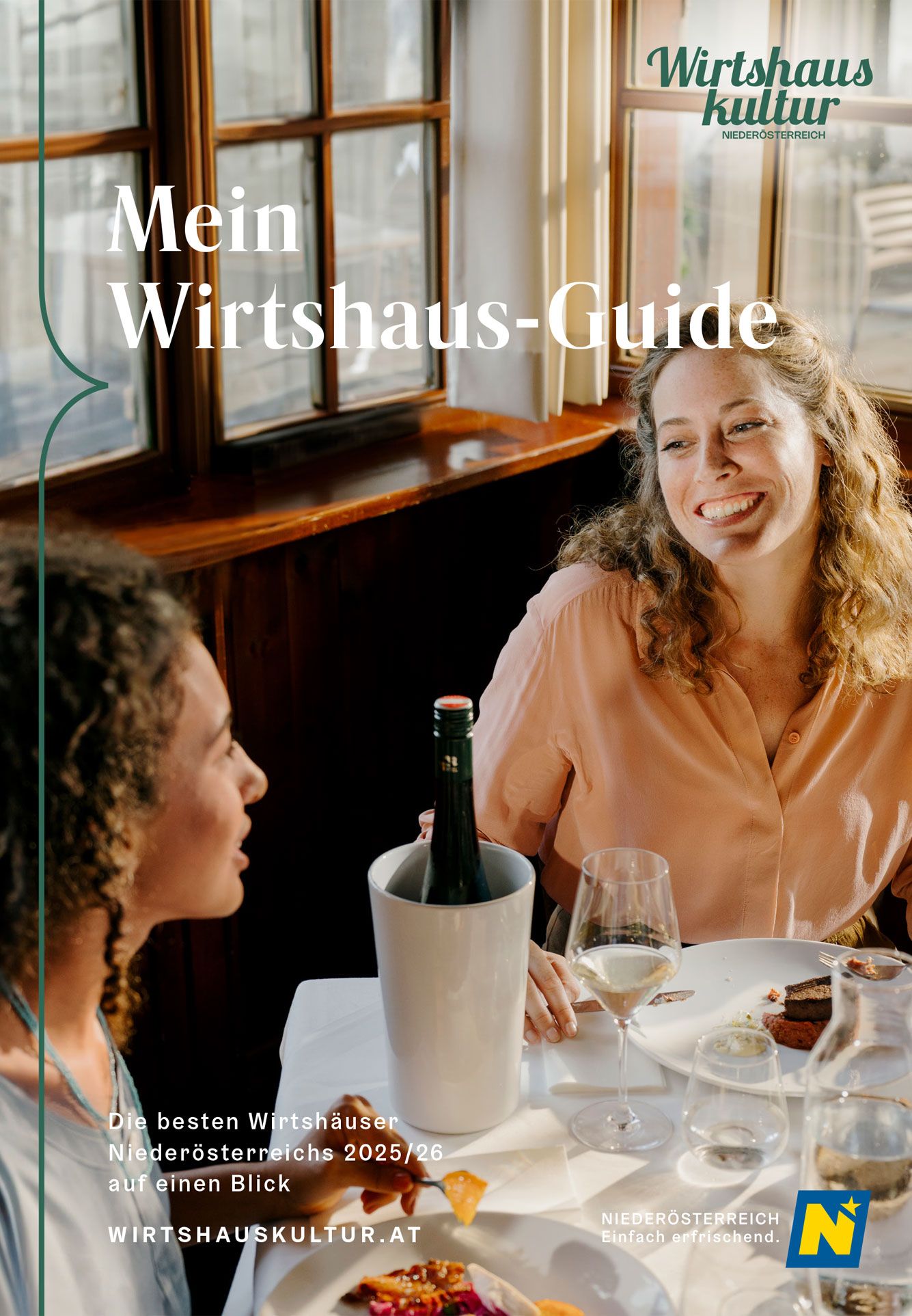 Cover der Broschüre "Mein Wirtshaus-Guide" der Wirtshauskultur Niederösterreich. Abgebildet sind zwei Frauen, die bei einem gedeckten Tisch sitzen, plaudern und lachen.  