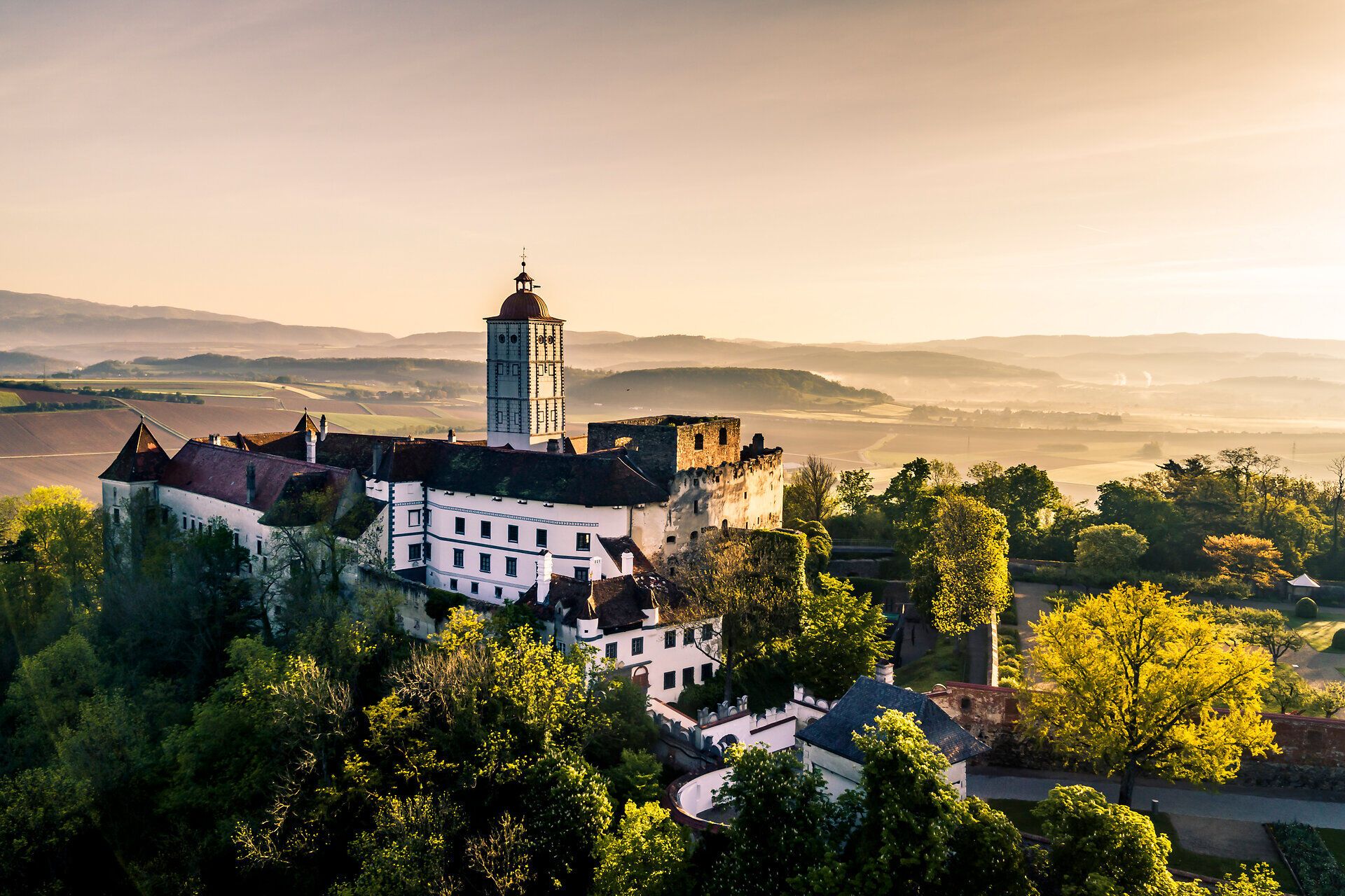Die majestätische Schallaburg erhebt sich stolz inmitten der blühenden Frühlingslandschaft. Umgeben von saftigem Grün und sanften Hügeln, strahlt das historische Bauwerk eine einladende Atmosphäre aus, die zum Entdecken einlädt.