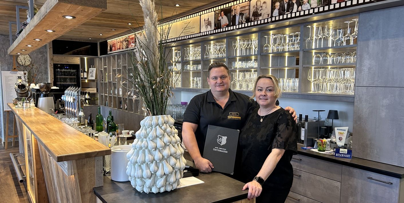 Familie Osterbauer hinter einer Bar im Restaurant Osterbauer.