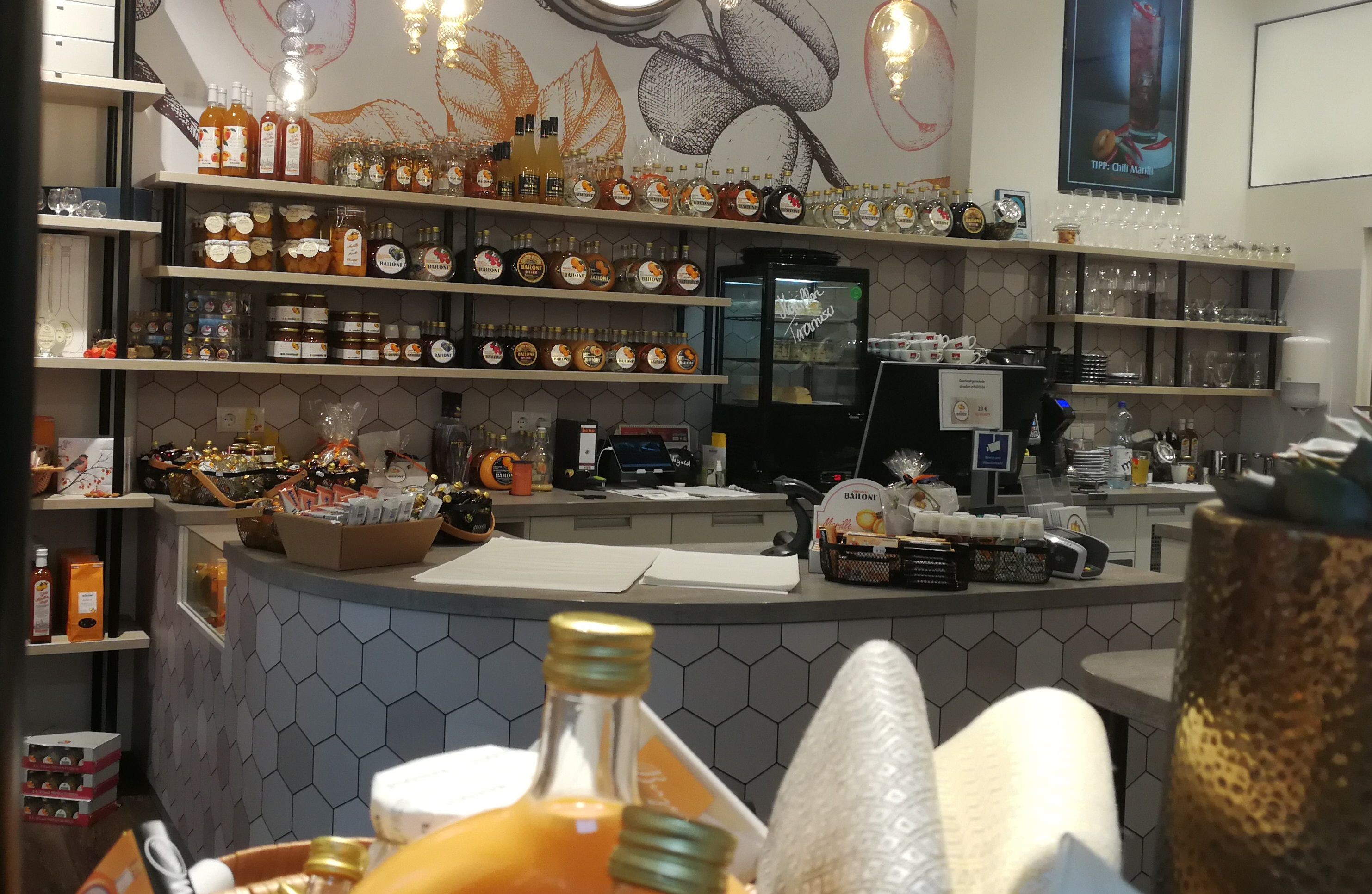 Innenansicht eines Ladens mit Regalen voller Likörflaschen und Marmeladengläser.