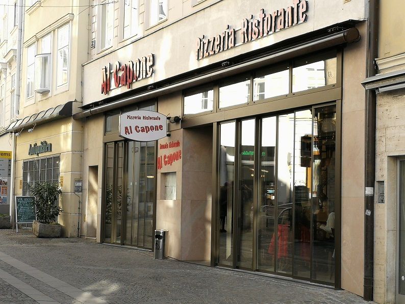 Eingang einer Pizzeria namens Al Capone in einer Einkaufsstraße.