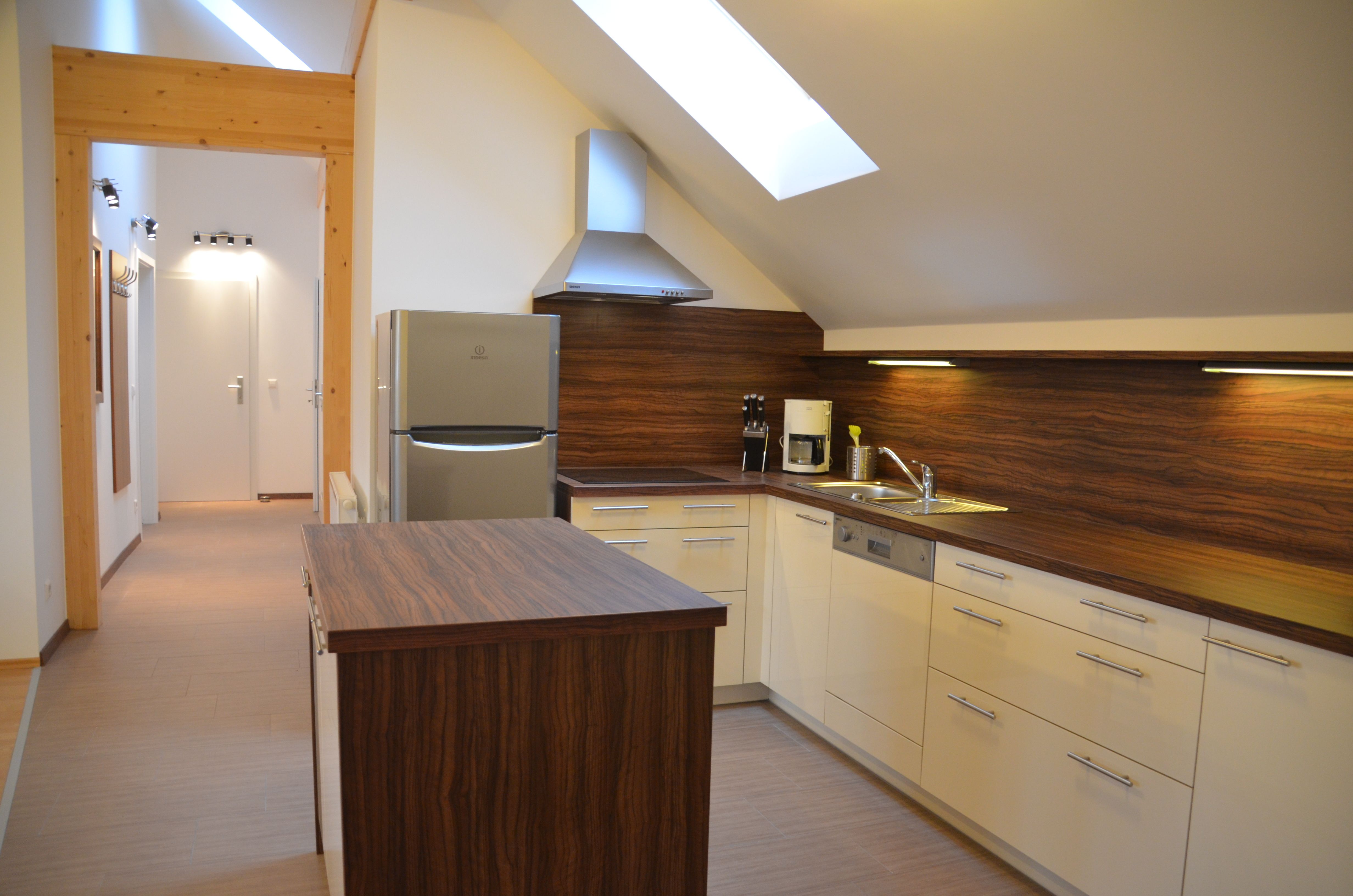 Moderne Küche mit Holzarbeitsflächen, Dachfenster und Geräten.