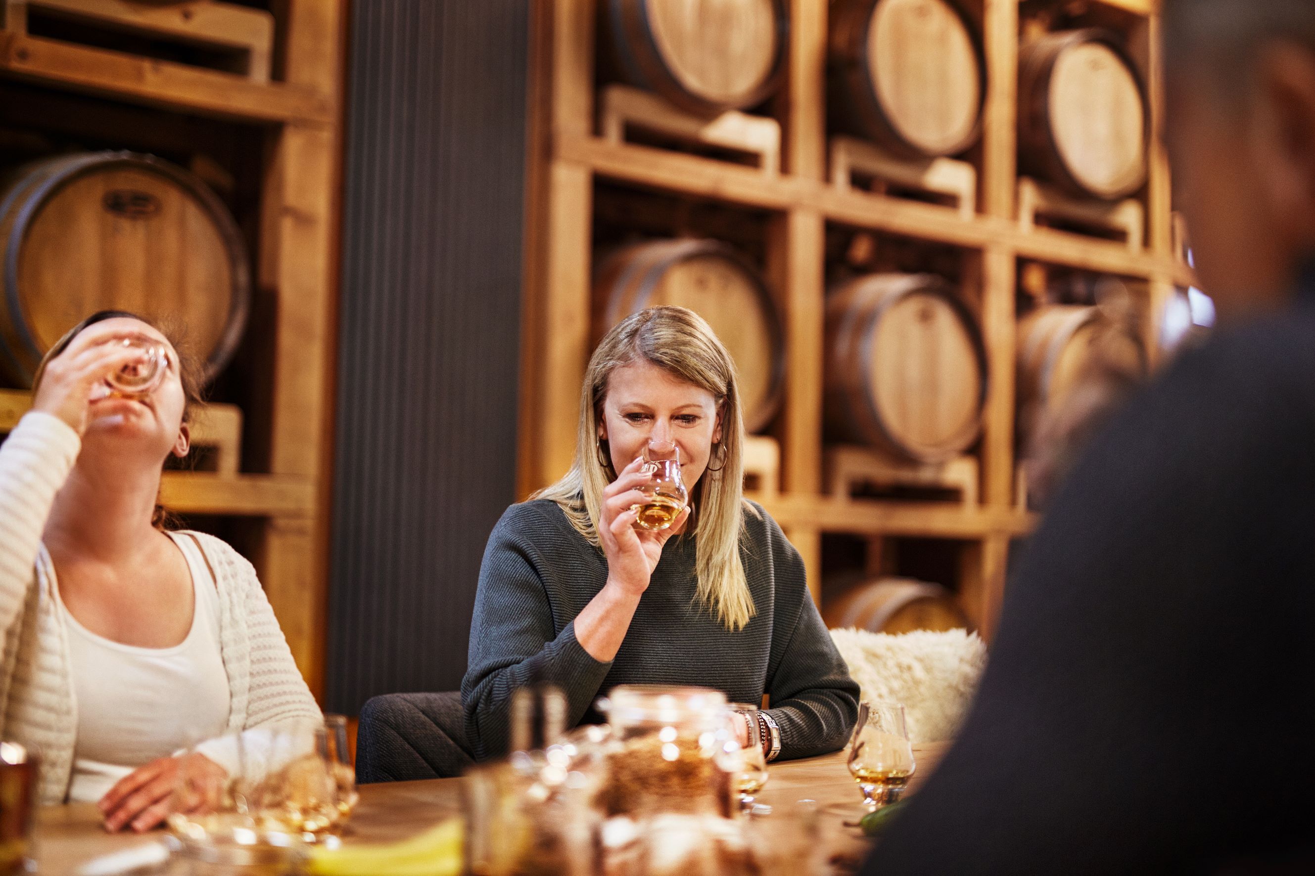 Personen bei einer Whisky-Verkostung in einer Destillerie.